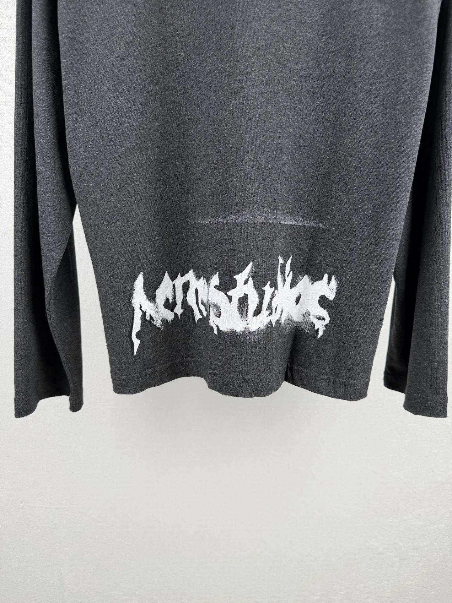 ACNE Studios printed graffiti logo distressed long-sleeved T-shirt. Customized air-oxygen soft matt jersey. Smooth and delicate, comfortable and skin-friendly. Cream White background. Retro luxury hidden in the distressed texture. Relaxed and high-end. The front and back are engraved with flame gothic fonts. Acne Studios' dark subculture edge flows naturally. Hand-carved holes and worn details reproduce the wild texture accumulated over time. The elegant collision of Nordic minimalist style and street rebellious spirit is interpreted to the extreme. Process 1: Adopt glue printing process. The printing is modified three times by the film screen. Use glue liquid paint to print the pattern on the fabric. Bake the fabric to fix the printed pattern. Process 2: Many parts of the body are worn by pure artificial regular positioning and hand brushing marks. Add texture and depth to the surface of the clothing to imitate the texture of natural wear. Process 3: The fabrics are fermented and washed, giving a better hand texture and not easy to deform. Not easy to shrink, not easy to fade, maintain long-term beauty Accessories: Customized 1:1 Acne trademark Version: Loose version Size: S M L XL